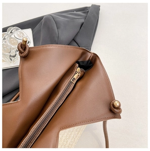 Detailed close-up of brown PU leather stitching and woven straw material with zipper