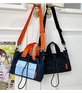 Détail d'un sac cabas en nylon avec cordon, poches contrastées et étiquette orange