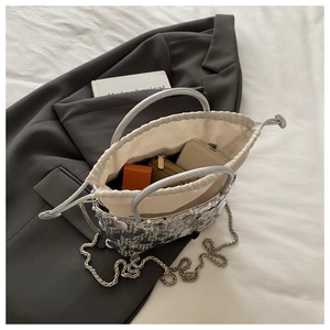 Capacity view of silver sequin bucket bag with drawstring closure and chain strap