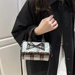 Chic blue star and brown plaid bow handbag shown worn by a model in a black coat