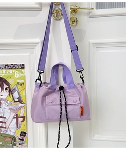 Détail du sac cabas en nylon lavande avec fermeture à cordon et étiquette orange