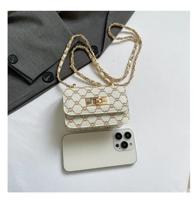 Detailed top view of a mini beige chain crossbody bag with vintage pattern and metal clasp