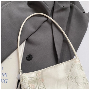 Detailed close-up of floral embroidery on ivory silk New Chinese style bucket bag