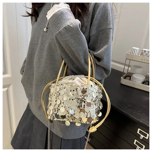 Close-up of champagne sequins, drawstring inner bag and metal chain strap of the bucket bag