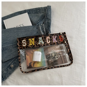 Detail of transparent PVC bag with leopard trim and colorful SNACKS embroidery