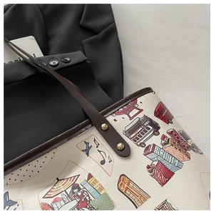 Détail de la poignée en cuir avec rivets dorés sur le sac fourre-tout graffiti