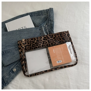 Detail of leopard print PVC makeup bag with transparent window and gold zipper detail
