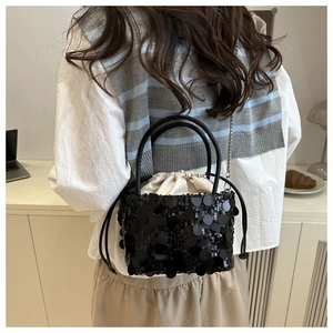 Detail of black sequin bucket bag with drawstring liner and silver chain strap