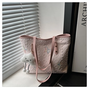 Detail of pink tote bag with quilted M texture, colorful butterfly and cloud charm