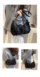 Detail of black sequin shoulder bag showing large round sequins and leather strap