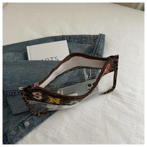 Detailed view of leopard print trim transparent PVC bag with colorful embroidery on denim