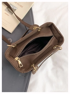 Top view of brown PU leather tote bag with gold zipper closure and dark fabric lining