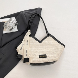 Chic woven straw tote bag with black leather trim and handles for beach or commute