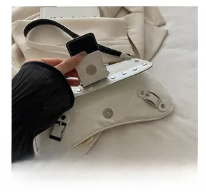 Detail view of the silver magnetic buckle and black interior on the white studded bag