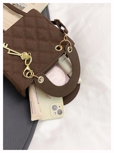 Detail view showing spacious interior of the brown quilted handbag with everyday essentials