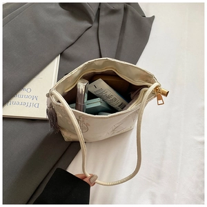 Detail of white tote bag interior showing large capacity for cosmetics with gold zipper