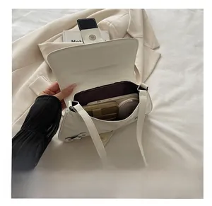 Interior view of the white patent leather shoulder bag showing large storage capacity