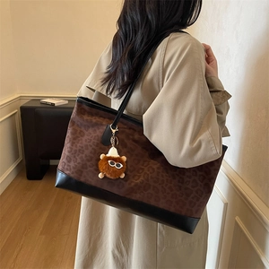 Retro leopard print tote bag with black leather straps and brown plush bear charm accessory