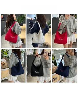 Detail view of the C'est la vie canvas tote bag in red, navy, cream, and black colors