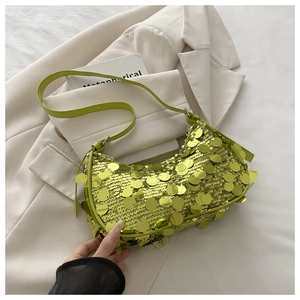 Detail of lime green sequin crescent bag on white blazer showing shiny metallic textures