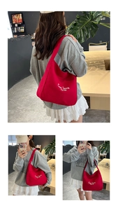 Detail of red canvas tote bag with white C'est la vie text and sturdy fabric texture