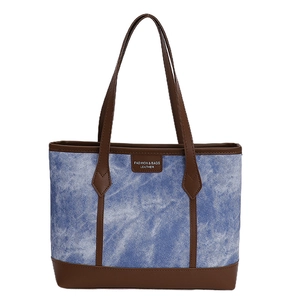 Blue denim tote bag with brown leather handles and spacious interior for daily commute
