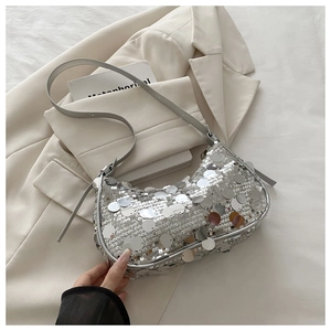 Close-up of sparkling silver sequin hobo bag on neutral blazer, ideal for evening wear
