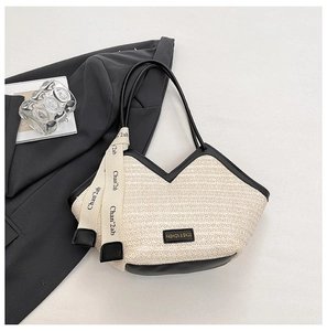 Detail of woven tote bag with black leather trim and branded logo label in minimalist setting