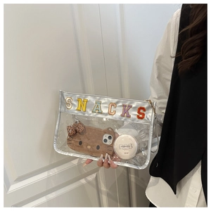 Detailed view of transparent PVC bag with snacks embroidery and silver trim