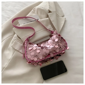Detail of pink sequin shoulder bag on white blazer with leather strap and silver buckle