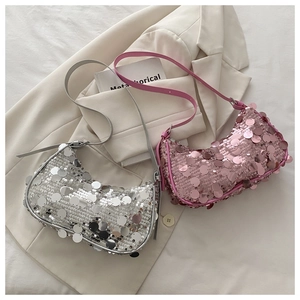 Chic silver and pink sequined crescent bags displayed on a stylish white suit jacket