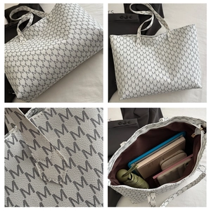 Detail showing large capacity interior and textured lychee leather with M print