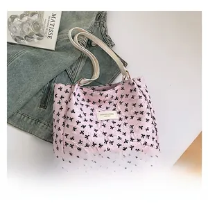 Sac fourre-tout rose avec motifs nœuds noirs et texture plissée élégante