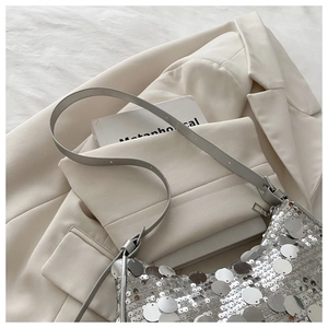 Close-up of shimmering silver sequins on the surface of a fashionable underarm shoulder bag