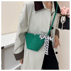 Detailed shot of green woven bucket bag with pearl closure and polka dot silk scarf detail