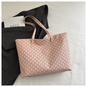 Pink tote bag detail with vintage M-letter pattern and high-quality leather texture