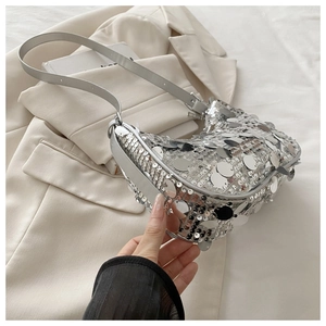 Detailed macro view of sparkling silver sequins and leather strap on a chic shoulder bag