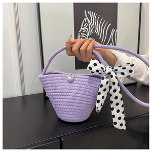 Detail of lavender woven bucket bag with pearl button and polka dot silk scarf bow