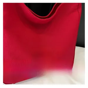 Detail of red canvas shoulder bag featuring white C'est la vie PAN'TOR embroidery