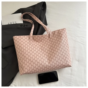 Detailed close-up of a pink monogram tote bag with M-letter prints on a white fabric base