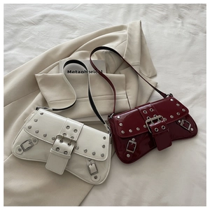 Detail of burgundy and white patent leather underarm bags with silver punk metal studs