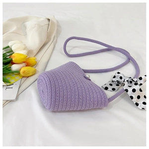 Detail of purple woven cylinder bag with large pearl buckle and polka dot silk scarf bow