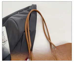 Detail showing the comfortable double shoulder straps of this brown lychee leather tote bag