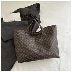 Detail of vintage brown tote bag with all-over M-letter print and large capacity