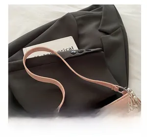 Detail of pink star-quilted leather bag with decorative pearl and silver metal chain strap