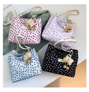 Vue détaillée de quatre sacs cabas matelassés à nœuds en rose, violet, bleu et noir