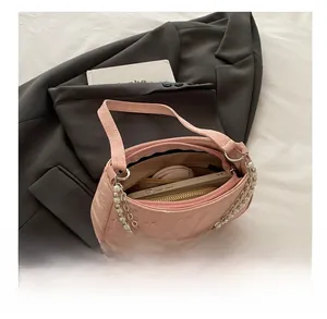 Detailed interior view of pink quilted chain bag showing phone and makeup storage