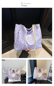 Détail du sac cabas matelassé lavande avec motifs nœuds et breloque en peluche marron