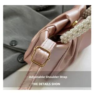 Detail showing the adjustable leather strap and elegant pearl handle of the pink cloud bag