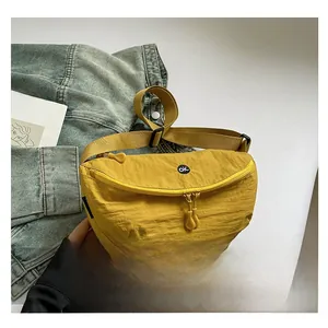 Detail of yellow nylon waist bag with OK patch, dual zippers and adjustable strap